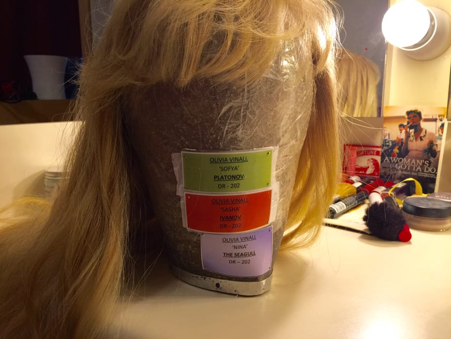 Into the dressing room, and the wig is waiting...